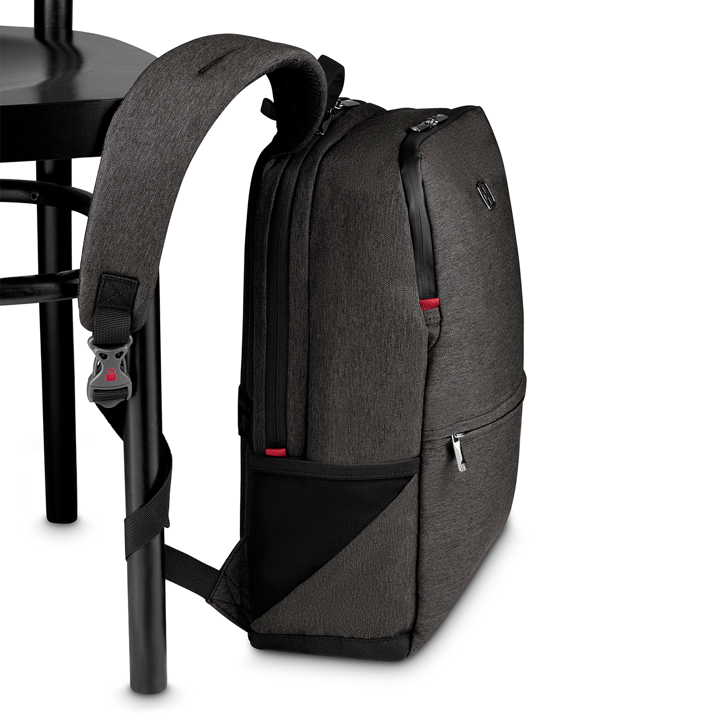 Dark gray backpack leaning against a black chair, close-up shot