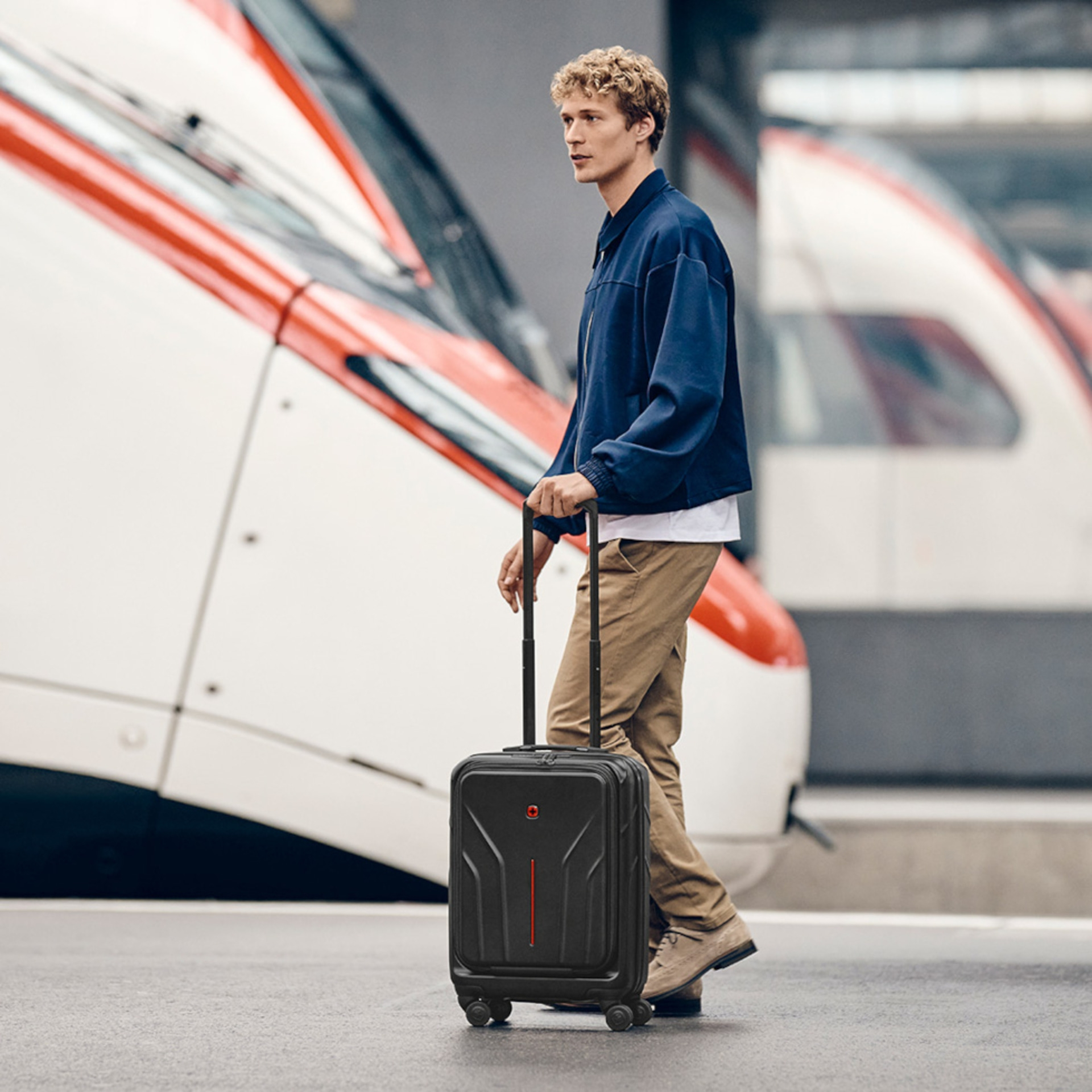 Man with suitcase at train station, waiting for train, travel luggage, on the go