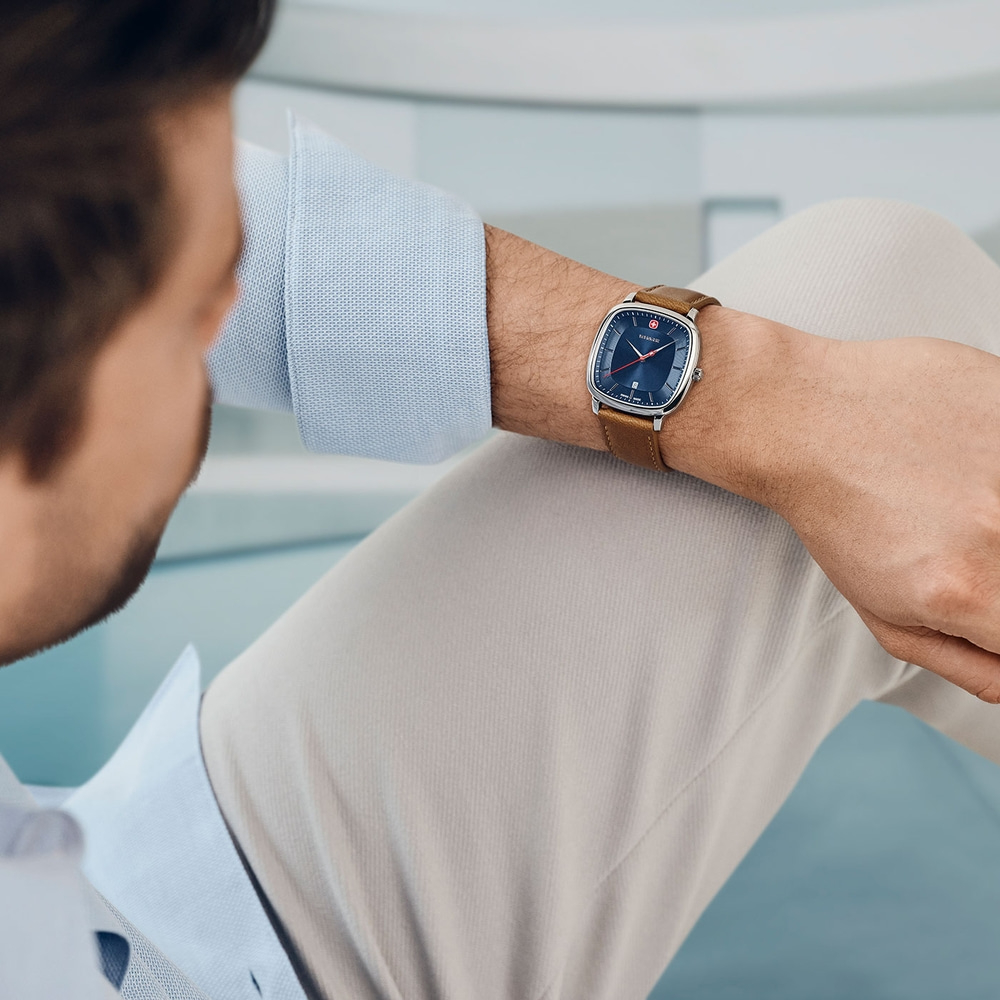 Man wearing watch, resting arm, close-up shot, light blue shirt