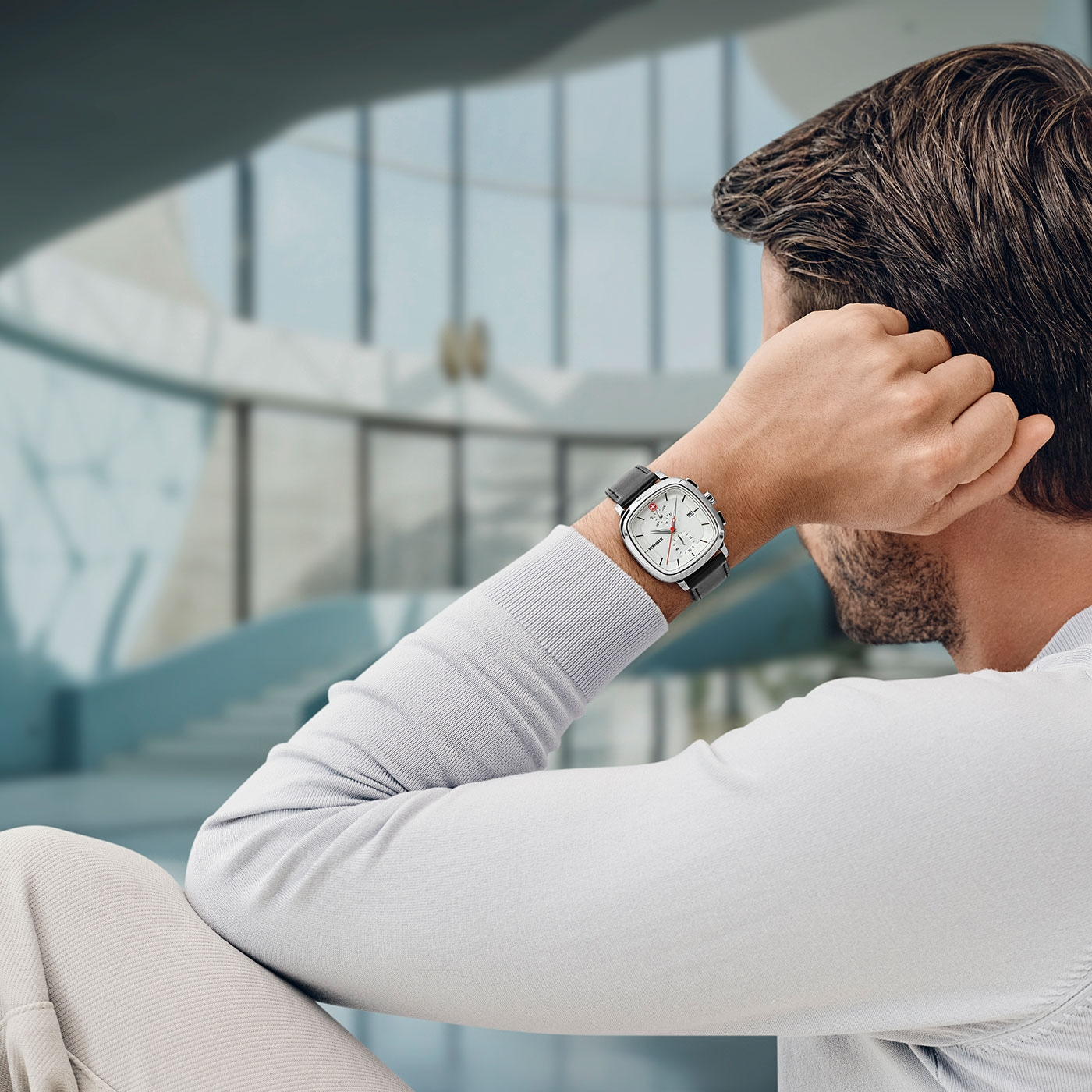 Man with watch relaxing and thinking in a building, looking away.
