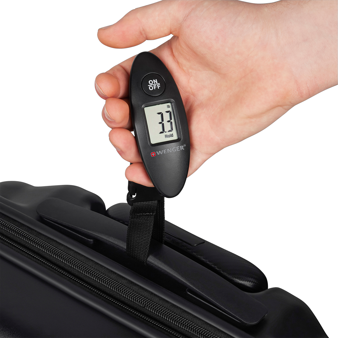 Hand holding luggage scale showing 3.3 lbs, with a black suitcase in the background.