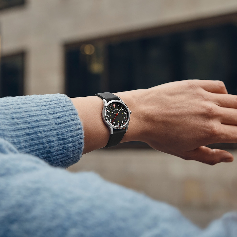 Watch on wrist, black dial, silver case, black strap, person wearing watch, close-up shot