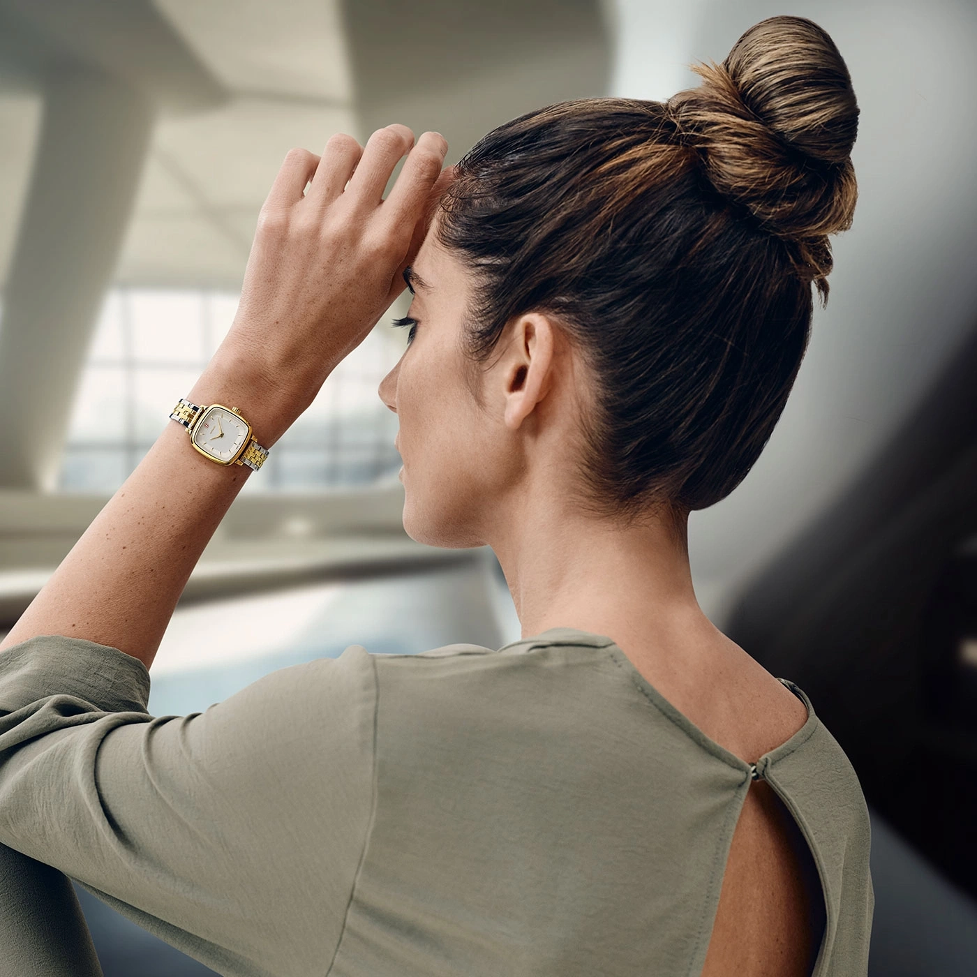 Frau mit Uhr, die sich die Hand an die Stirn hält, nachdenklich