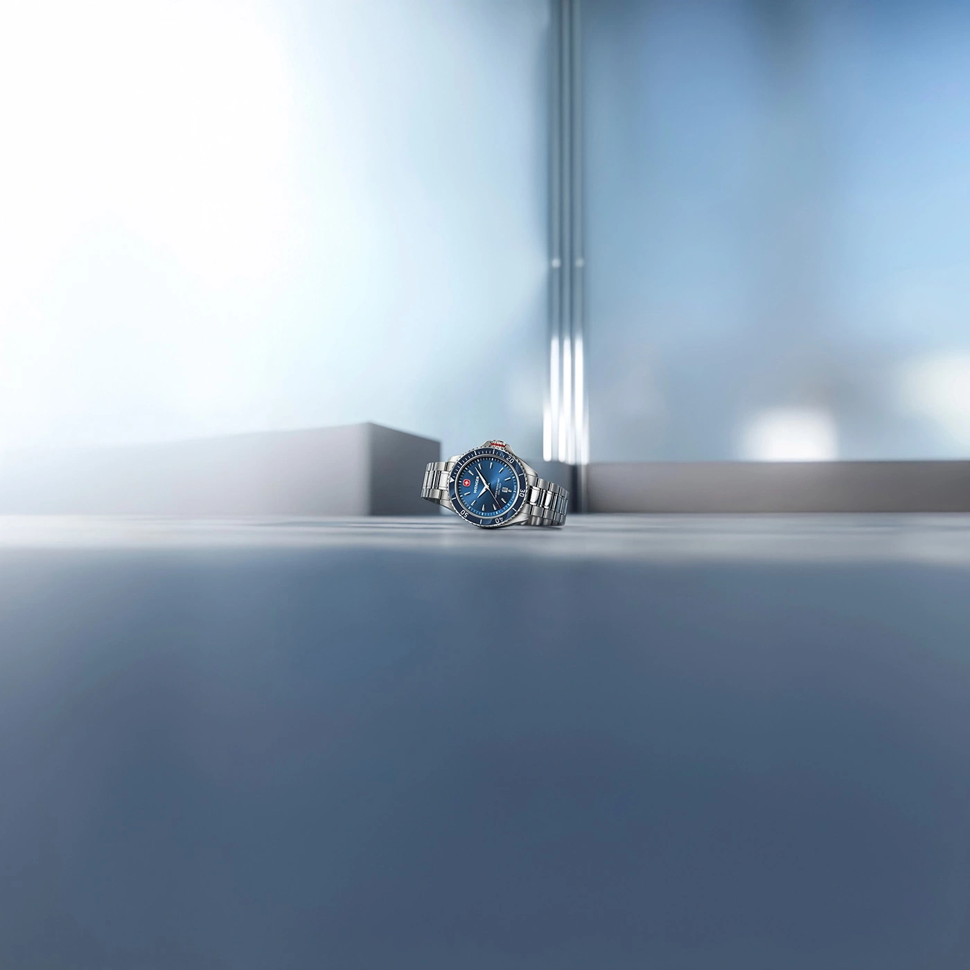 Blue wristwatch on a smooth gray surface with a blurred background.