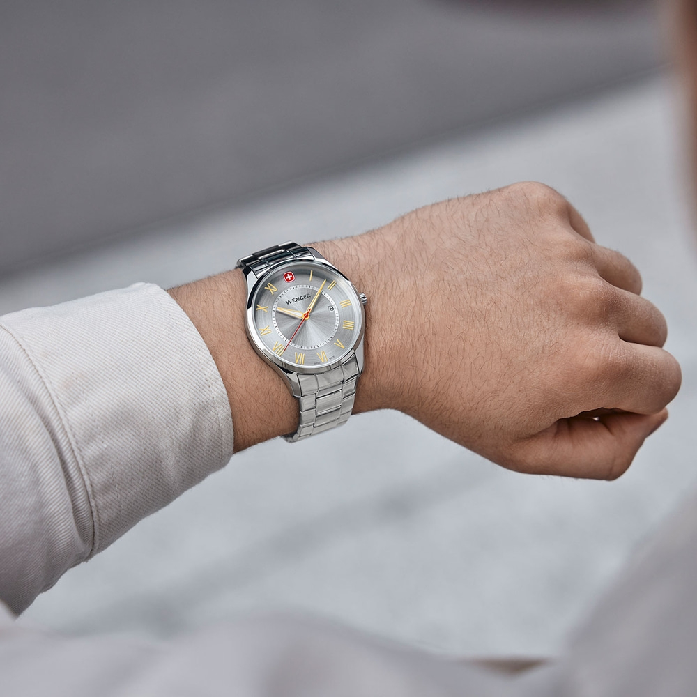 Wristwatch with silver face, gold roman numerals, Wenger brand, stainless steel bracelet