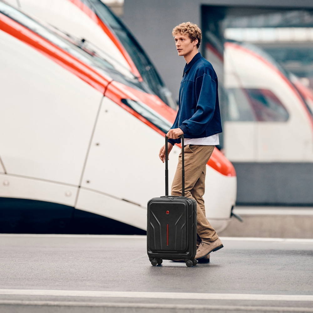 Man with suitcase at train station, train in background, travel, transport