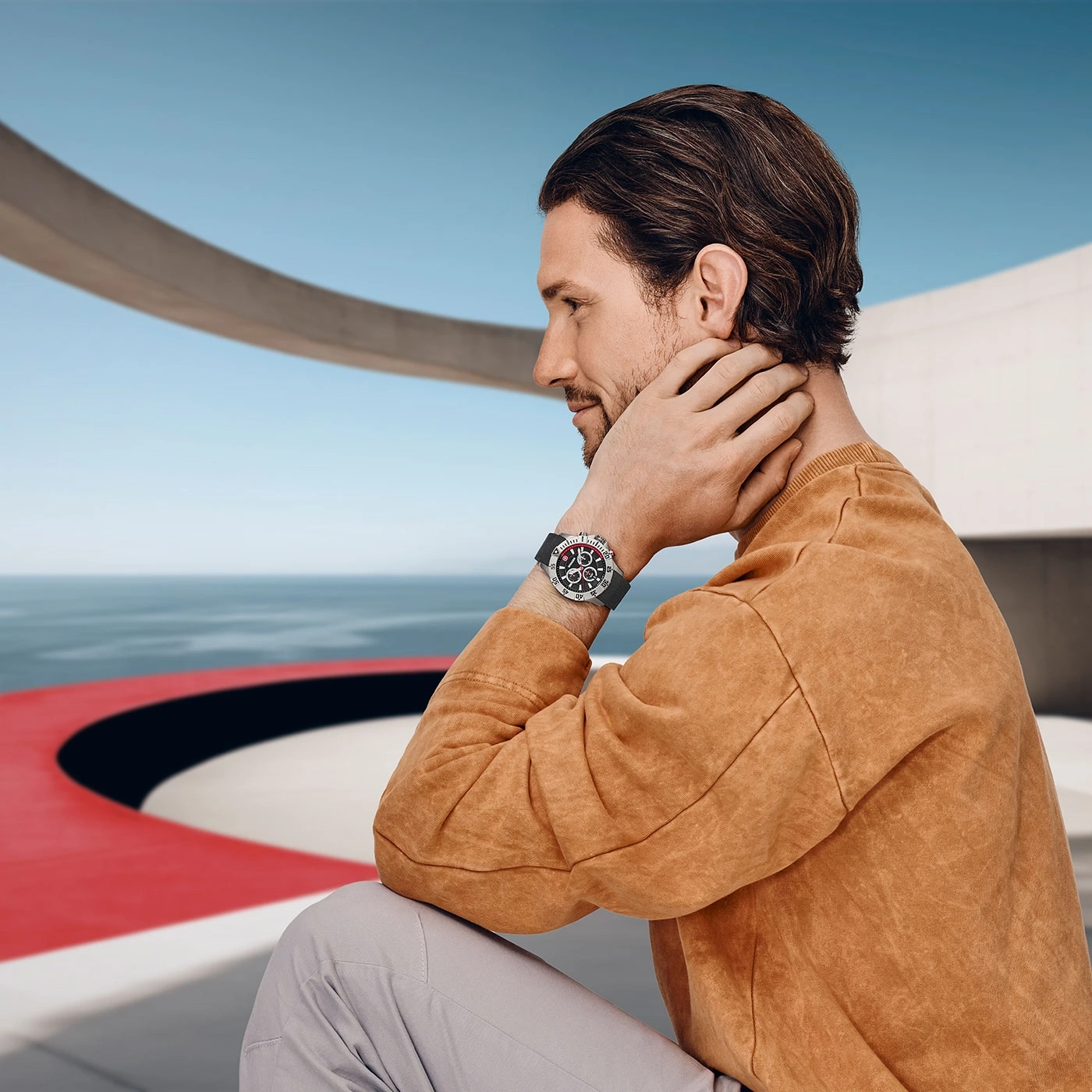 Man with watch looking at the sea in a modern building, side view