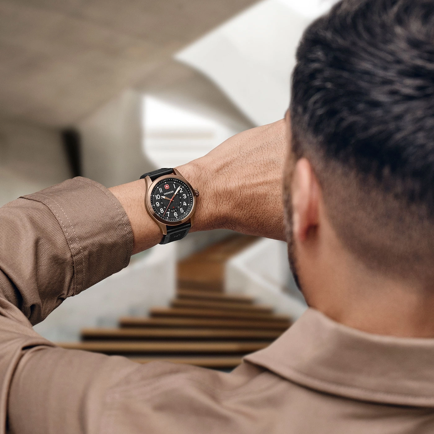 Man looking at his watch in a building, close up.