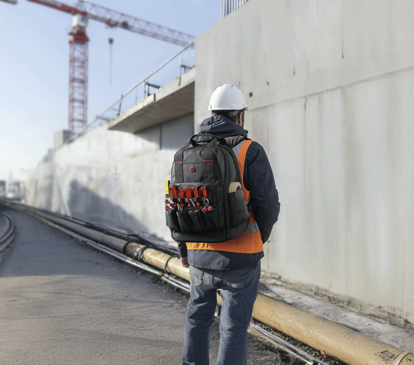 Construction worker with tool backpack at construction site