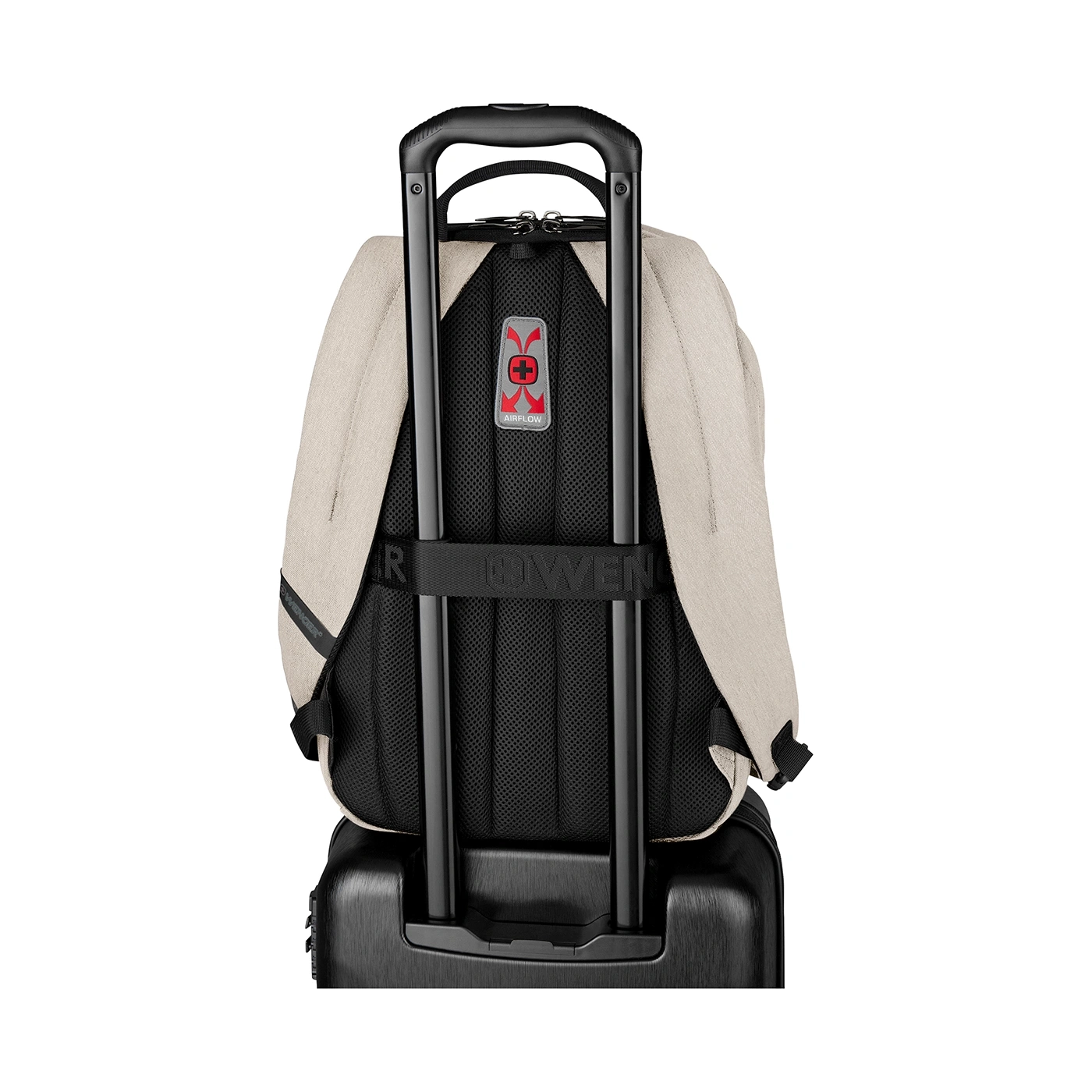 A backpack on a suitcase with a handle.