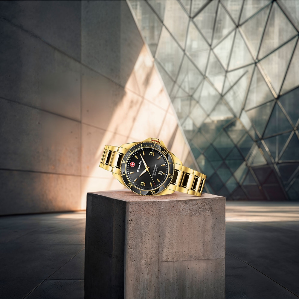 Golden watch on concrete block in front of modern building
