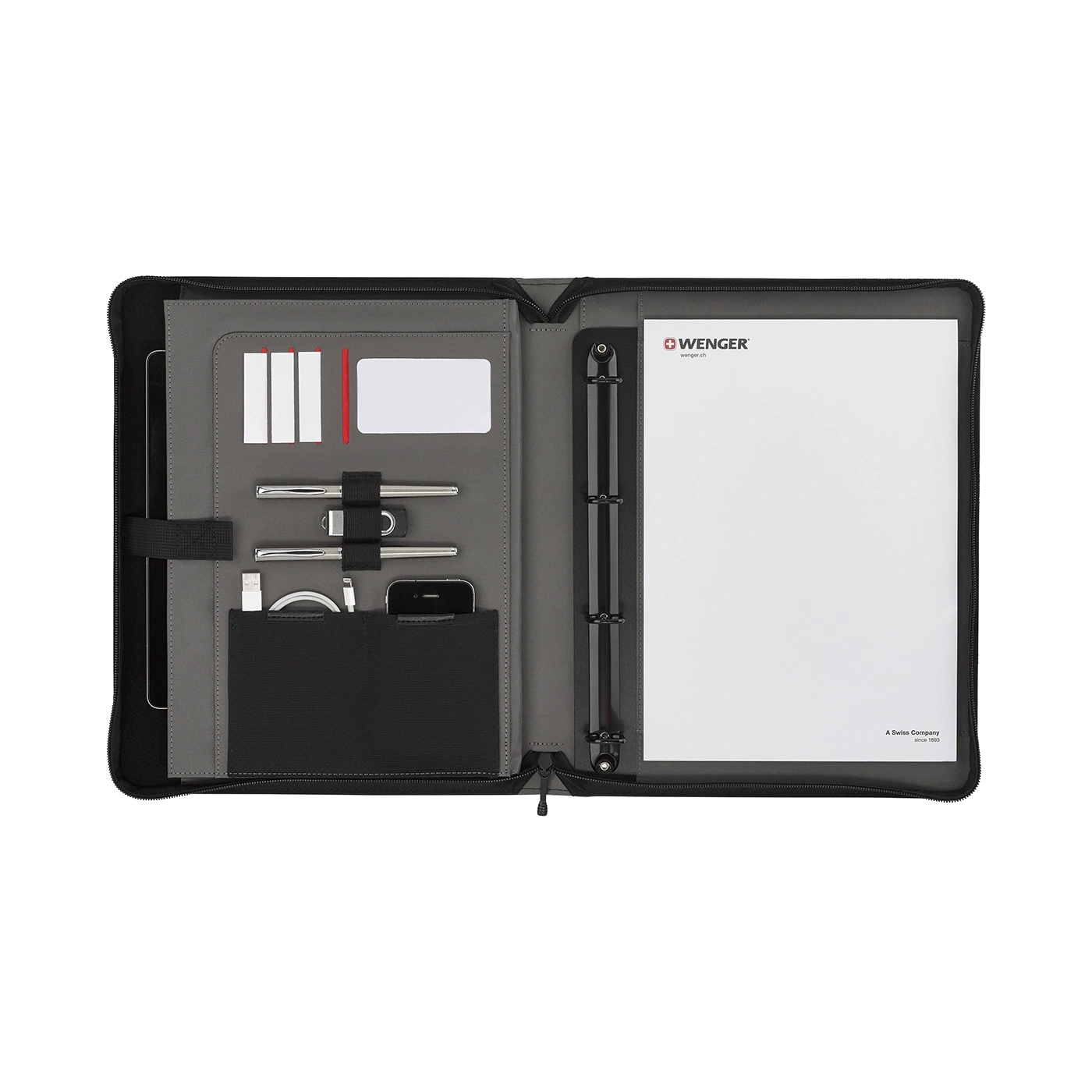 Black briefcase with accessories and paper, opened on a black background.