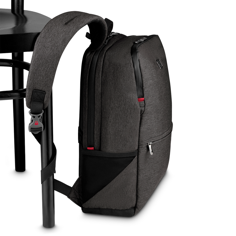 Dark gray backpack leaning against a black chair, close-up shot