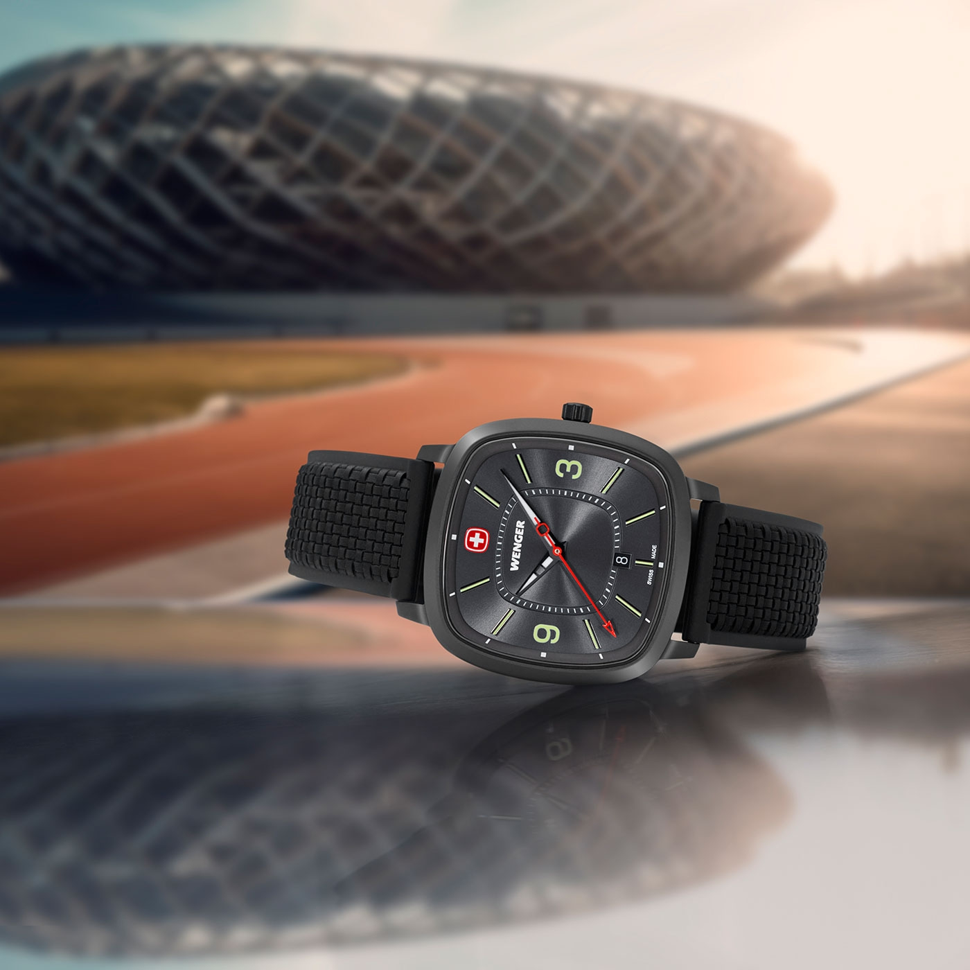 Wenger watch with black strap in front of a stadium background