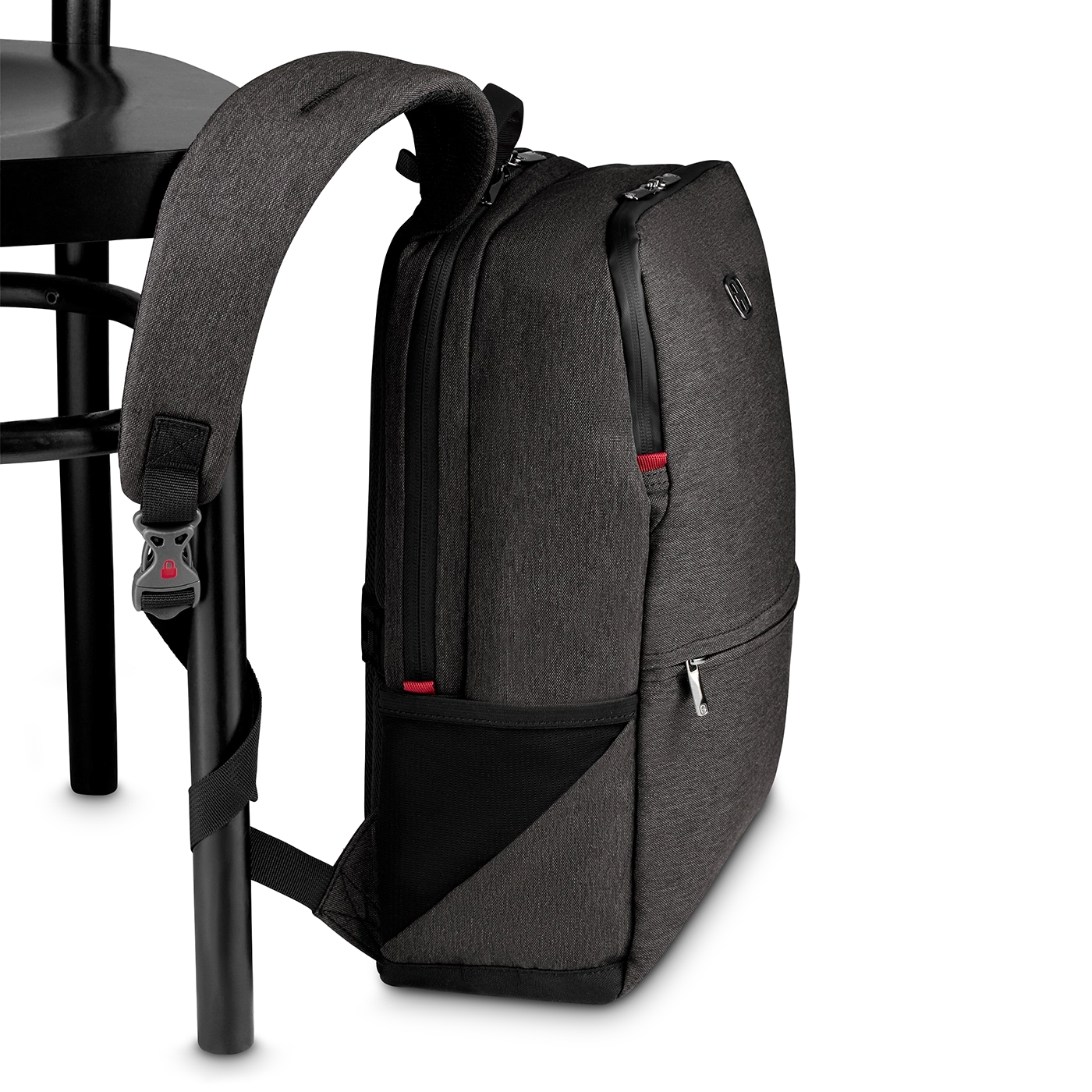 Dark gray backpack leaning against a black chair, close-up shot