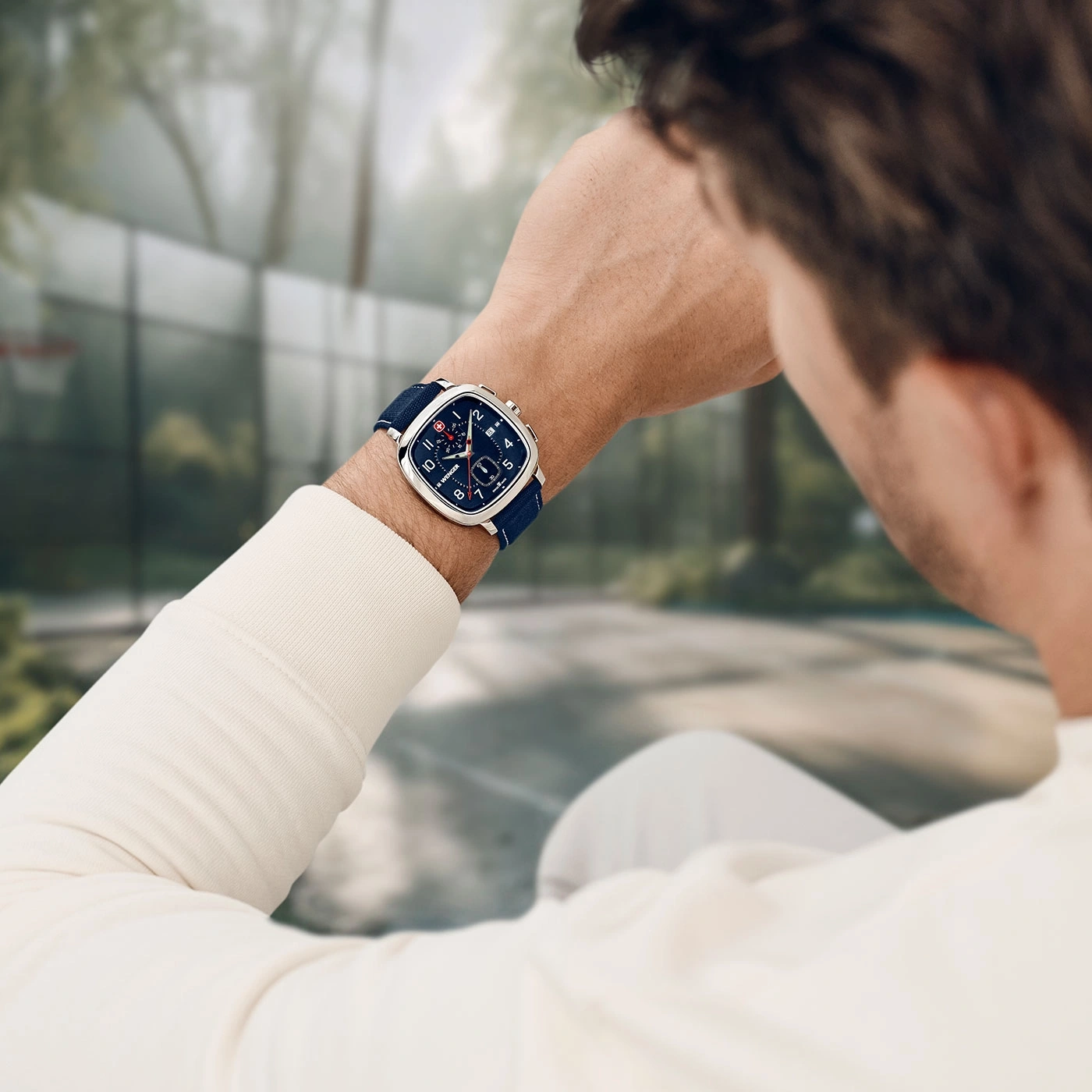 Mann mit Uhr, die er im Freien trägt, mit verschwommenem Hintergrund.