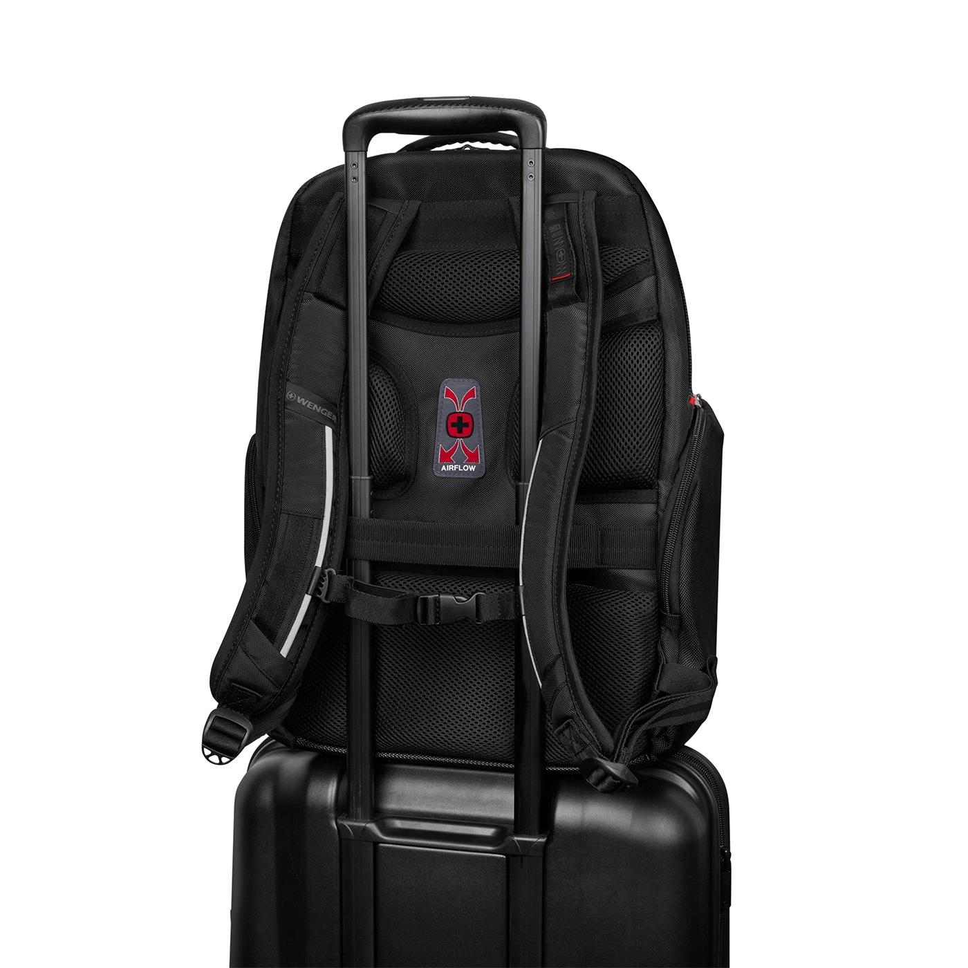 Schwarzer Rucksack auf einem Koffer mit Airflow-System und Wenger-Logo.