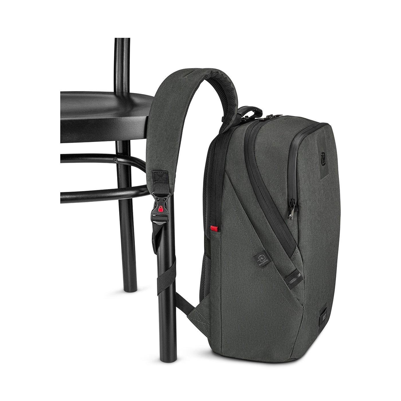 Dark gray backpack by a black chair, close-up shot, isolated on black background