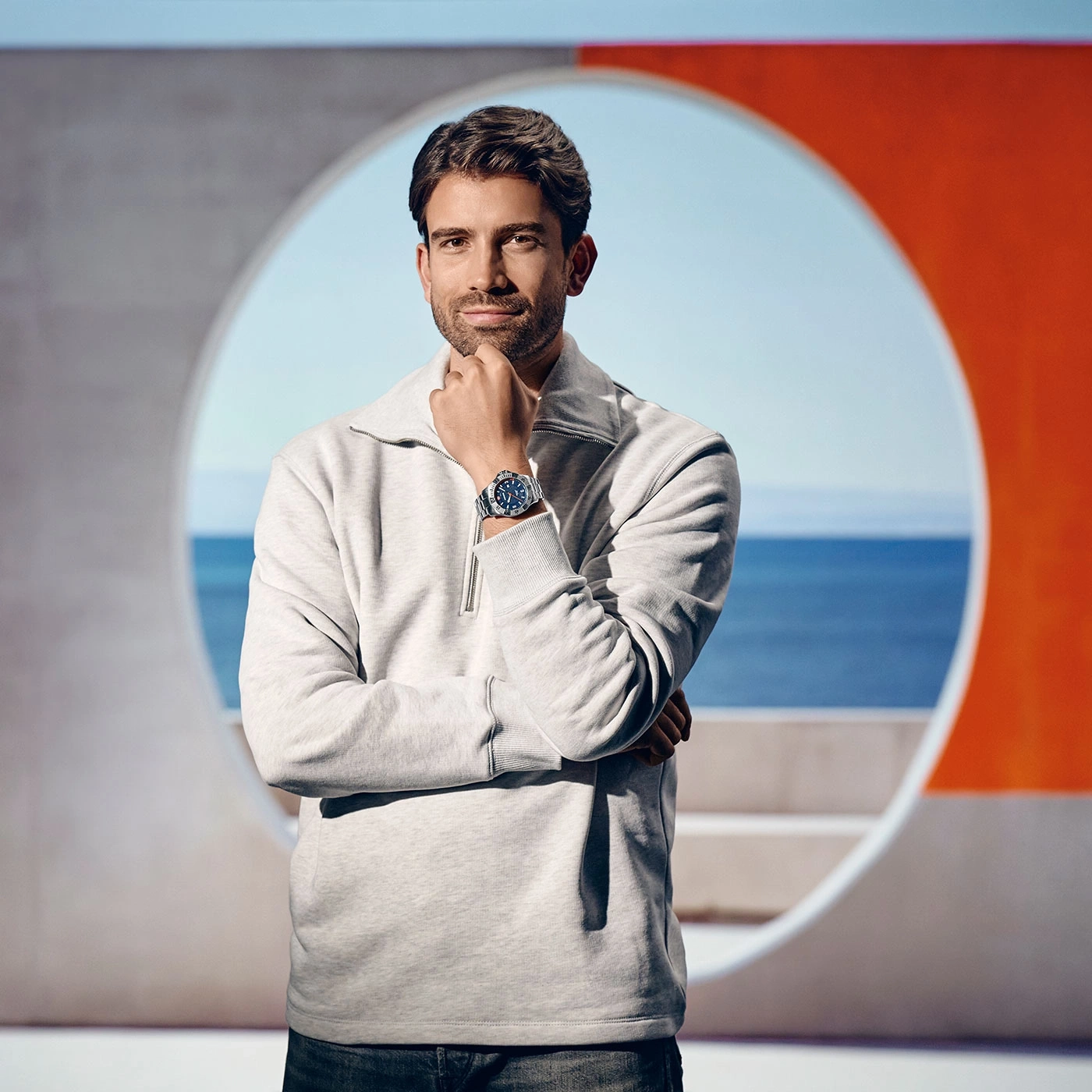 Man with watch, modern background, sea in background, thoughtful pose