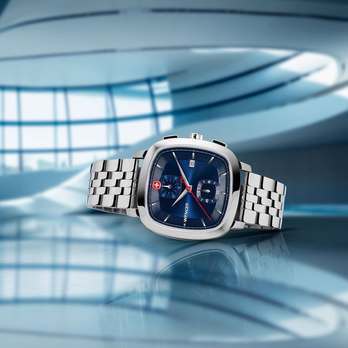 Close-up of a Wenger watch with blue face and silver bracelet.