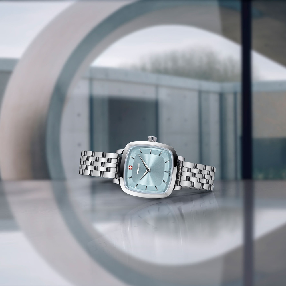 Watch with light blue face and silver band, set against a modern background